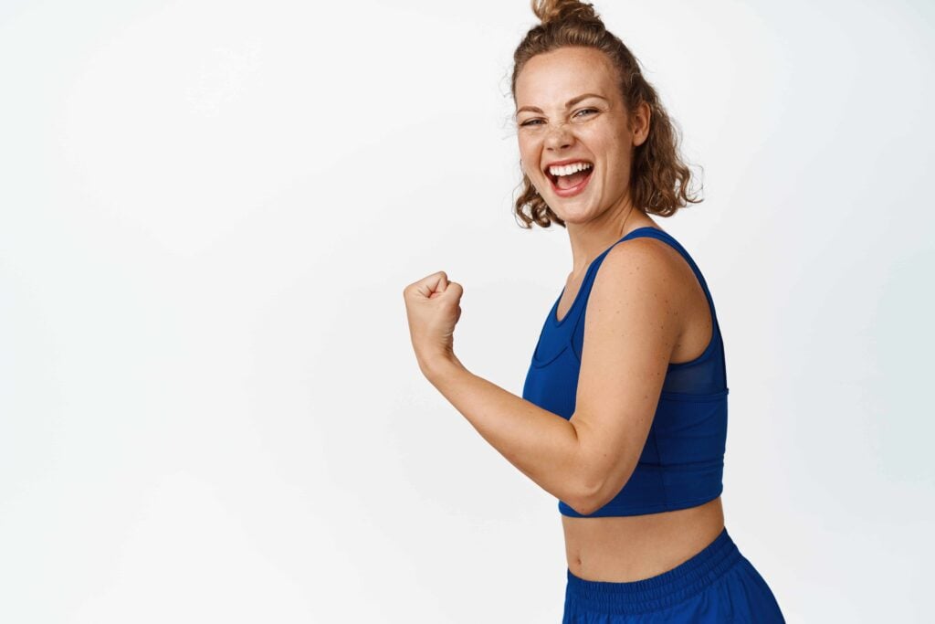 A postpartum woman smiling feeling strong
