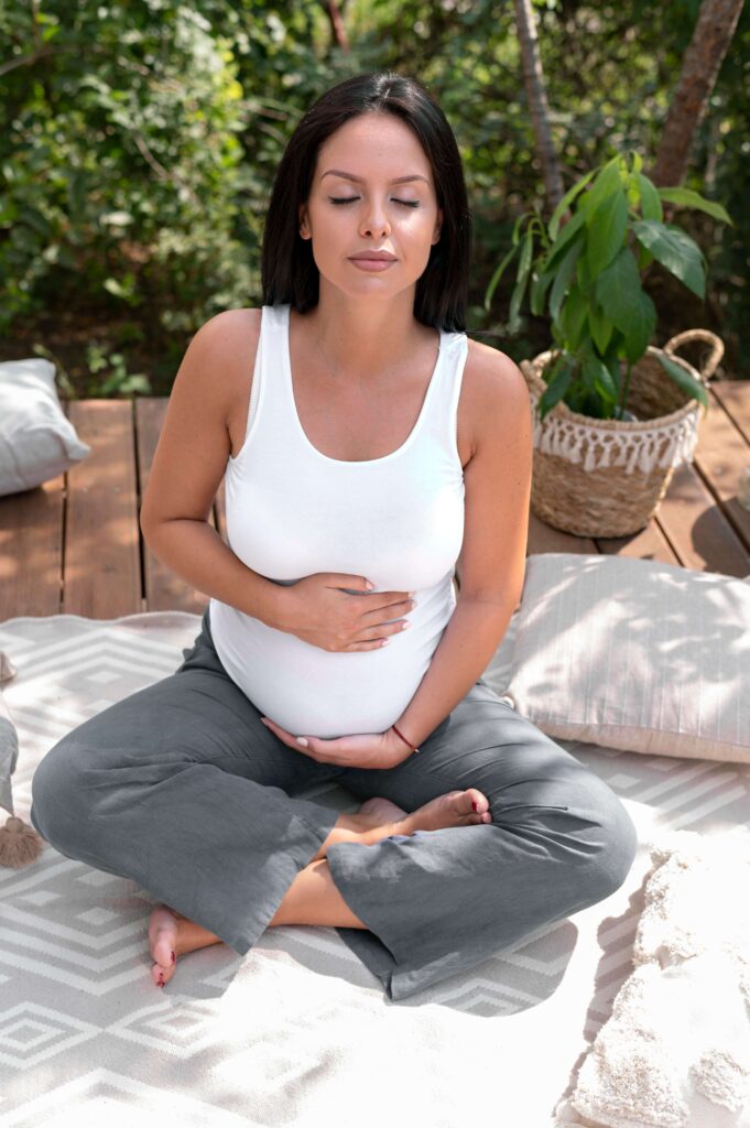 A pregnant woman breathing deeply and holding her belly.
